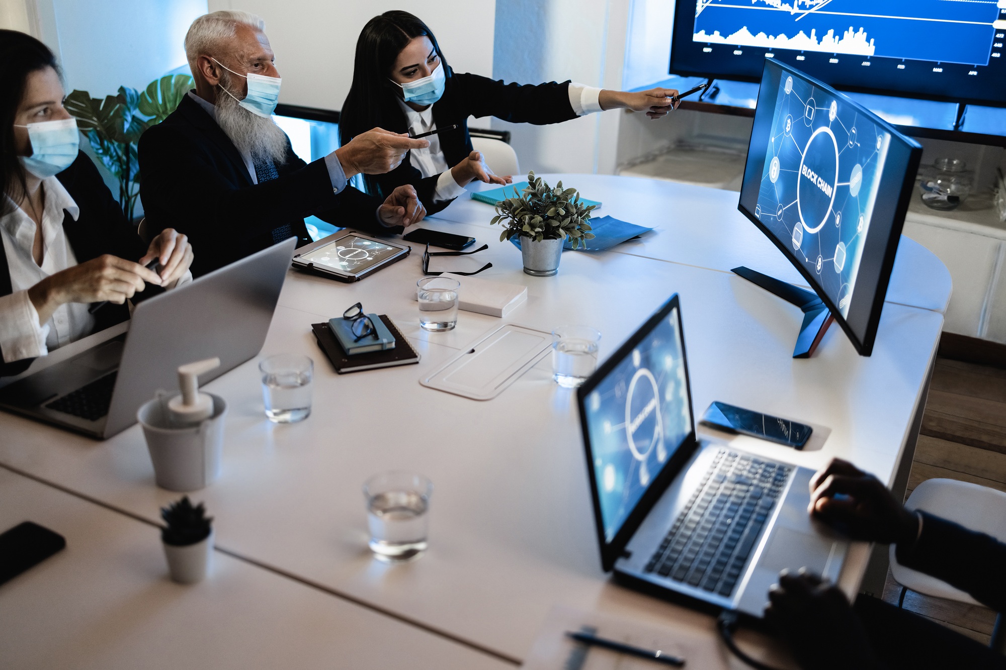 Business teamwork doing meeting inside fintech company office wearing safety mask
