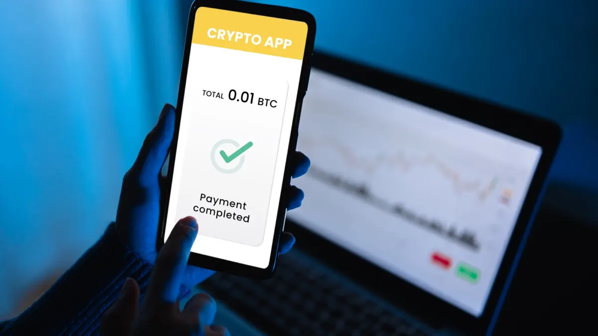Person making a cryptocurrency payment on a mobile phone wallet app