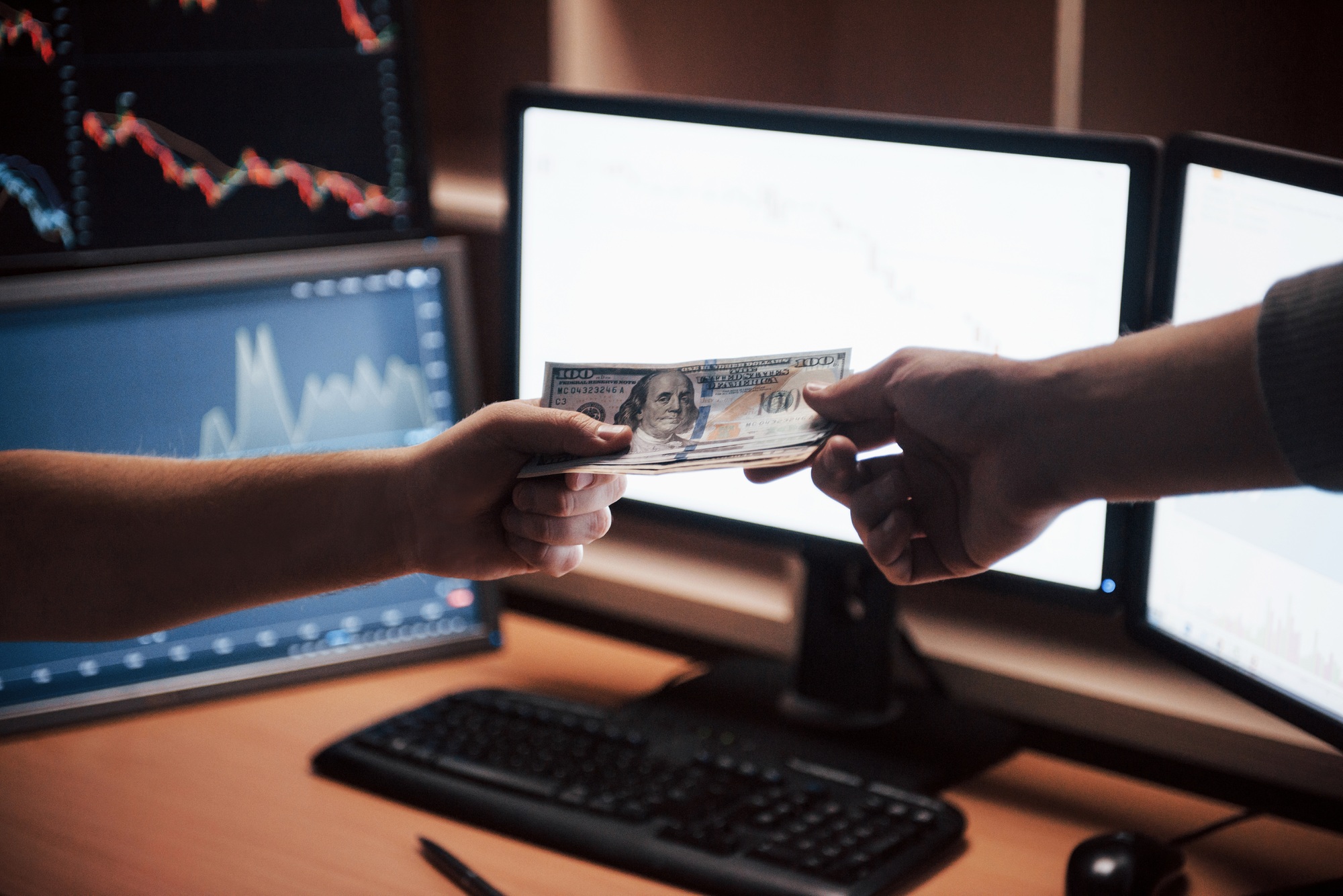 Here's your payment. Day of salary in the modern office with screens and graphs on them