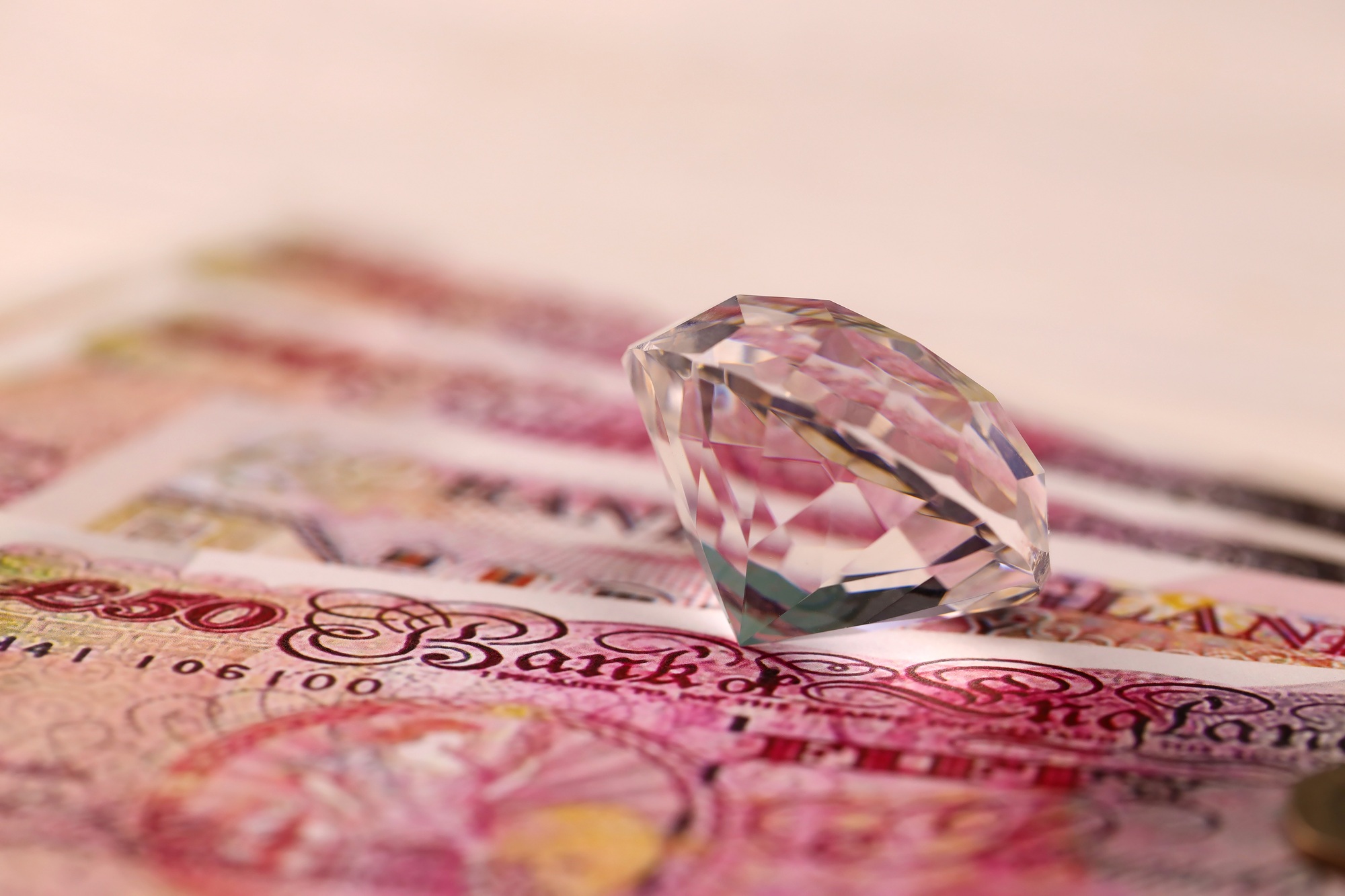 UK money bills with large diamond close up. Big amount of United Kingdom pounds