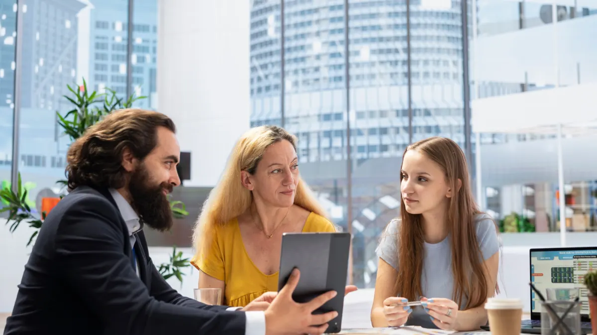 Financial advisor using software on a tablet to calculate a client's net worth