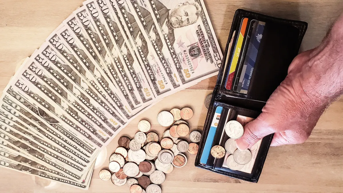 Overhead flat lay of household finance papers and notes used to plan weekly spending for a monthly budget