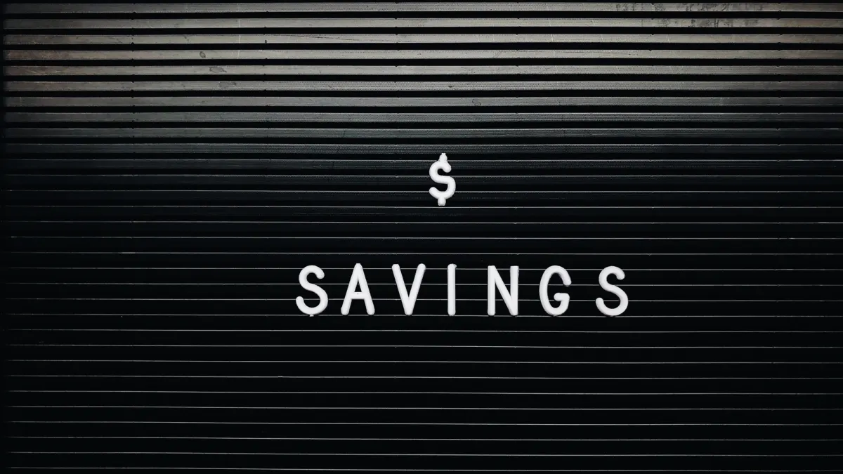 White letters spelling a dollar sign and the word Savings on a black letter board