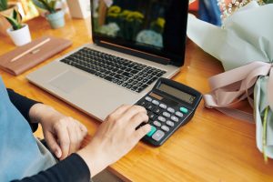 Shop owner calculating price of bouquet